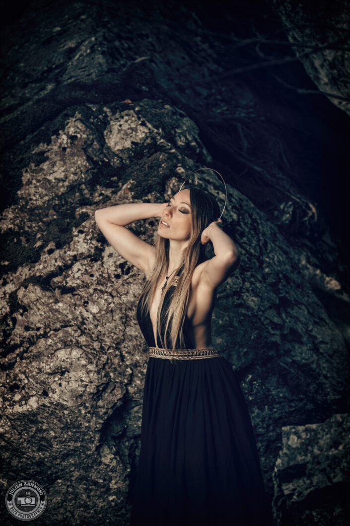 Floriane en robe noire dans une forêt rocheuse, photographie artistique par Julien Zannoni