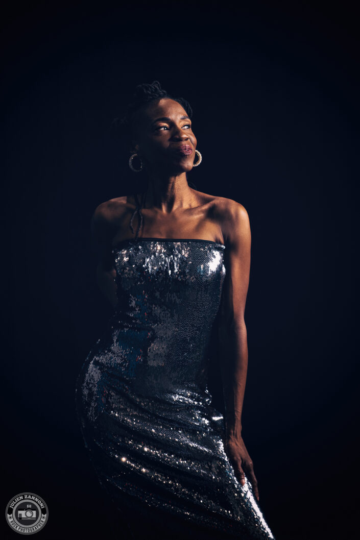 Teneia Sanders posing in a sparkling dress during a photoshoot – photo by Julien Zannoni.