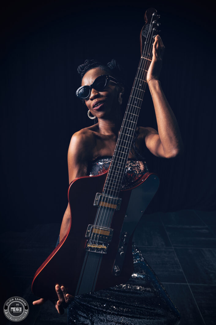 Portrait of Teneia Sanders posing with her electric guitar – photo by Julien Zannoni.
