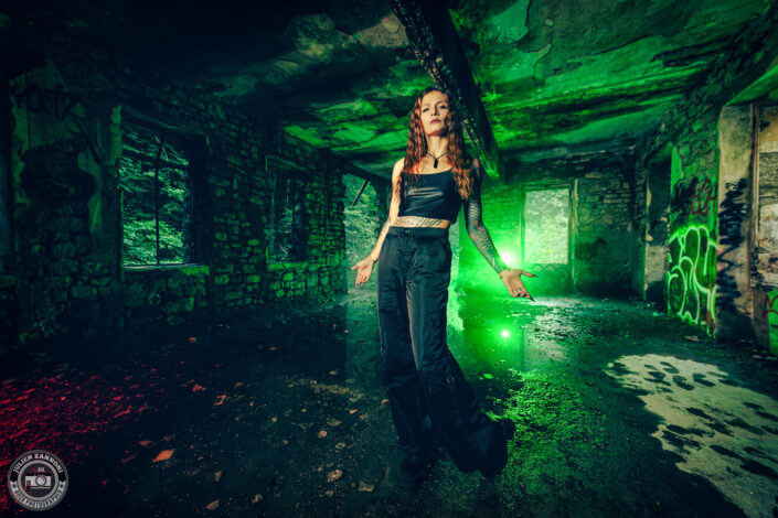 Barbara Mogore, chanteuse du groupe Nightmare, posant dans un lieu abandonné avec un éclairage vert toxique.