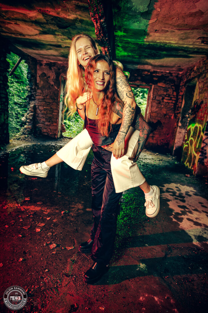 Barbara Mogore, chanteuse de Nightmare, avec sa sœur Lydia dans un lieu abandonné, éclairage rouge et vert.
