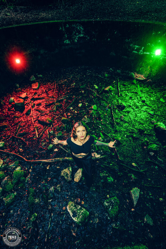 Barbara Mogore, chanteuse de Nightmare, dans un ancien bassin de baignade abandonné, éclairé en rouge et vert.