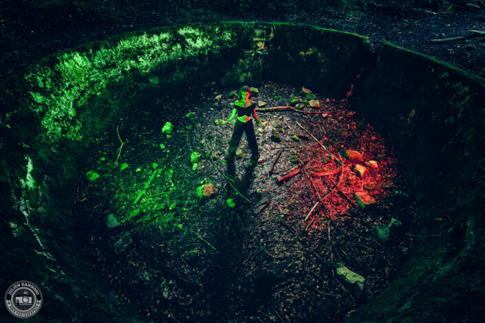 Vue plongeante de Barbara Mogore, chanteuse de Nightmare, dans un bassin de baignade abandonné éclairé en rouge et vert.