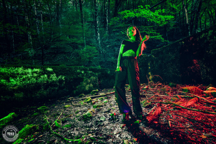 Barbara Mogore, chanteuse du groupe Nightmare, debout dans un bassin abandonné éclairé en rouge et vert.