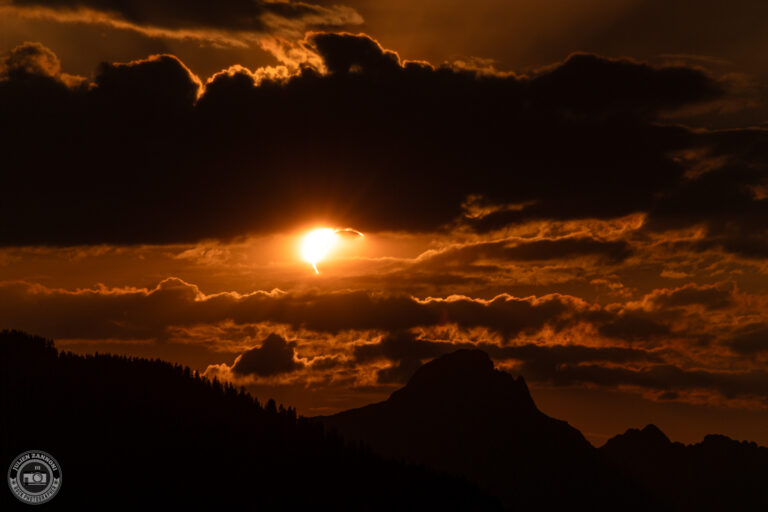Montagnes des Alpes sous un ciel orange pendant une éclipse solaire