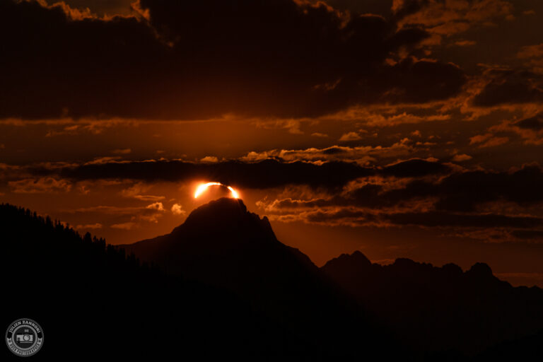 Coucher de soleil orange avec une éclipse solaire dans les Alpes